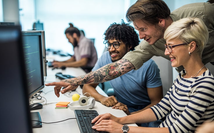 E-shop developers look at a computer screen together.