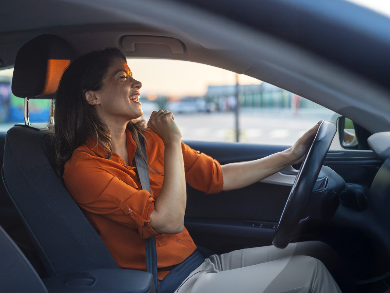 Businesswoman is driving a new car acquired through leasing.