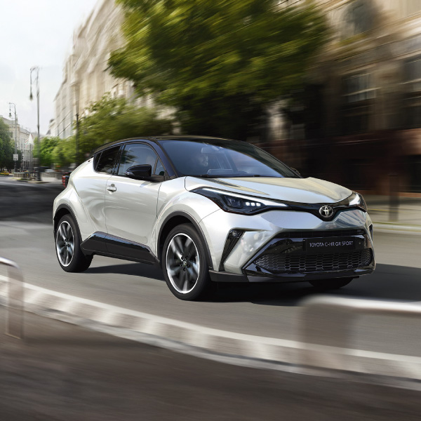 Baltas įmonės automobilis TOYOTA važiuoja gatve.