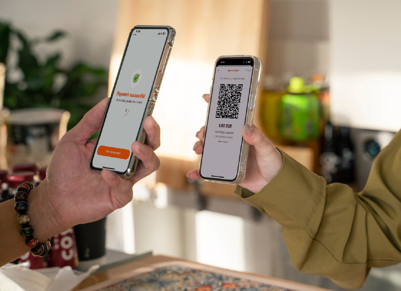 A woman shows her friend how she used the Money Request on her smartphone to pay via the Swedbank mobile app.