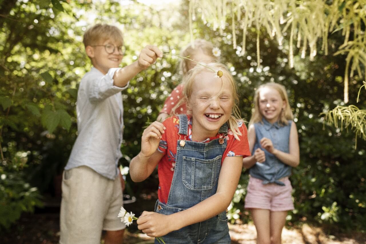 Vaikai džiaugsmingai žaidžia lauke